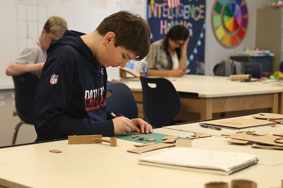Carefully cutting down a piece of cardboard, freshman Cory Schiffman works to build his cardboard sculpture on Friday, April 13. “I liked that we had the freedom to choose what to sculpt out of cardboard for the project,” Schiffman said. “I learned that you can make a lot of interesting things out of a simple material.” 