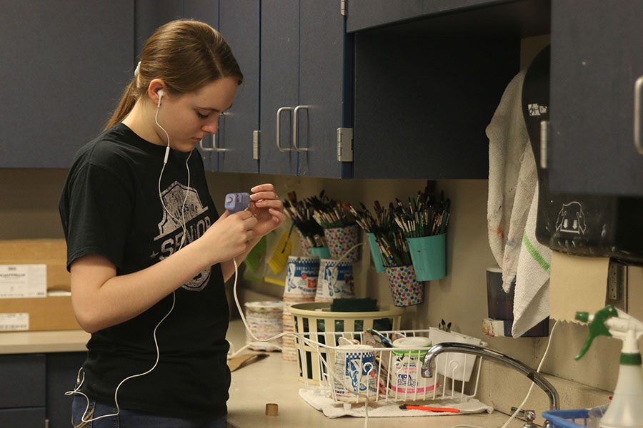 With a hot glue gun in hand, senior Ashley Ebner glues together pieces of cardboard for her sculpture on Friday, April 13. “I really enjoyed this project because it’s cool to try and make a three-dimensional object out of something two-dimensional,” Ebner said. “It was challenging to create something interesting out of a material that isn’t very interesting, but I liked it.” 