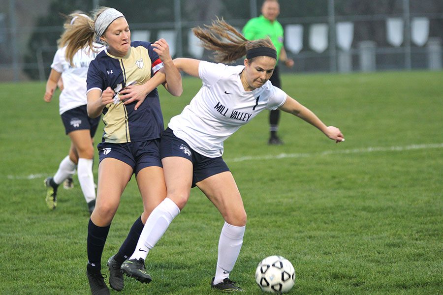 After winning the ball away from the Aquinas player, senior Gracie Eckardt retains possession.