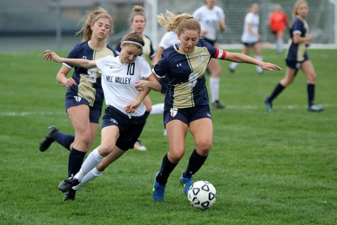 Racing towards the ball, senior Payge Bush battles with an Aquinas midfielder in Mill Valleys 1-0 loss to Saint Thomas Aquinas on Tuesday, April 24.