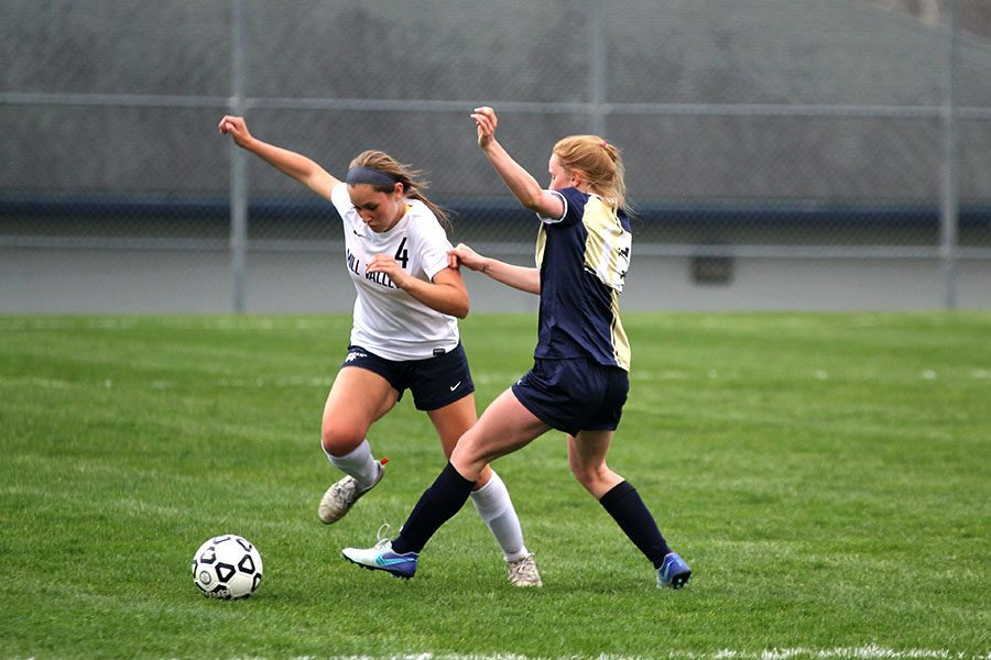 Under pressure from an Aquinas midfielder, sophomore Ella Shurley maneuvers her way out of trouble. 
