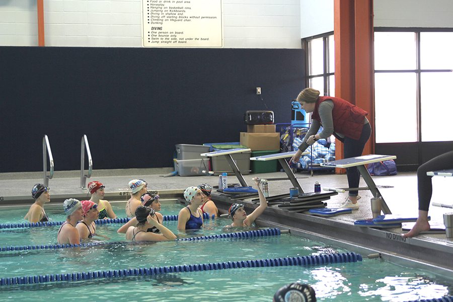 Pointing down towards the pool, head coach Kelly Downward talks to swimmers during practice on Thursday, March 8. 