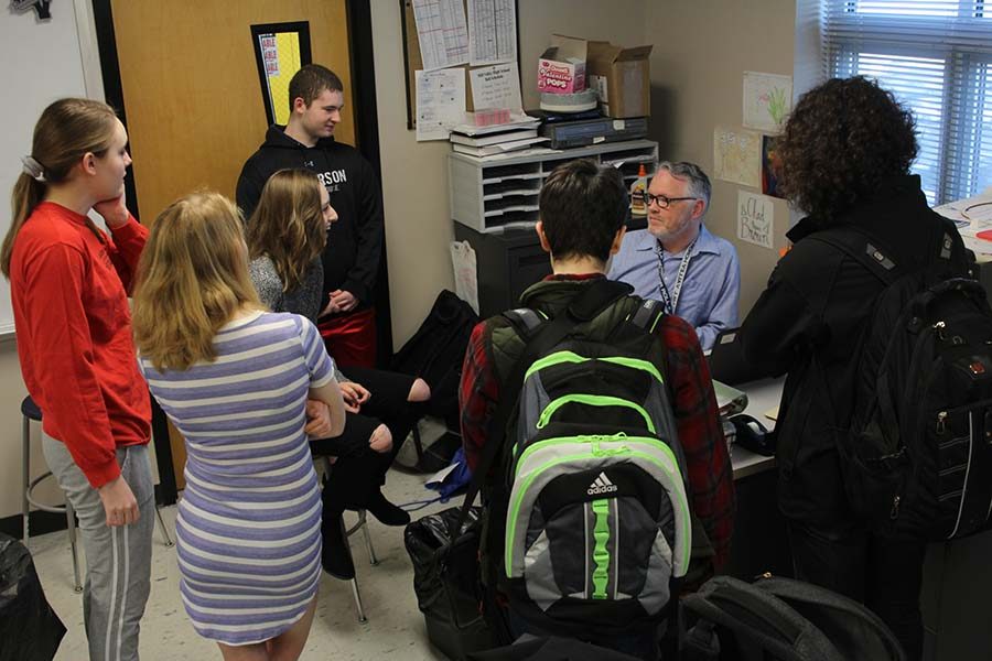 Crowded around science teacher Chad Brown's desk on Tuesday, April 10, students utilize their free time before school to hang out together. "All my friends like to hang out in there in the morning," senior Ashley Ebner said. "We pretty much are all in Science Olympiad, so it's another chance for us to all just chill and get ready for the day."