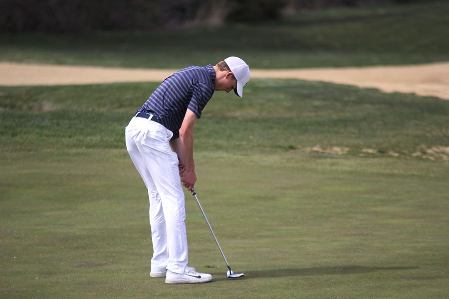 Focusing on the ball, junior Blake Aerni lightly putts his golf ball to finish up hole 12 on Wednesday, April 11.