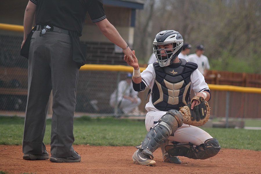 Accepting a backup ball from the umpire, junior Ethan Judd crouches in the field on Tuesday, April 25.