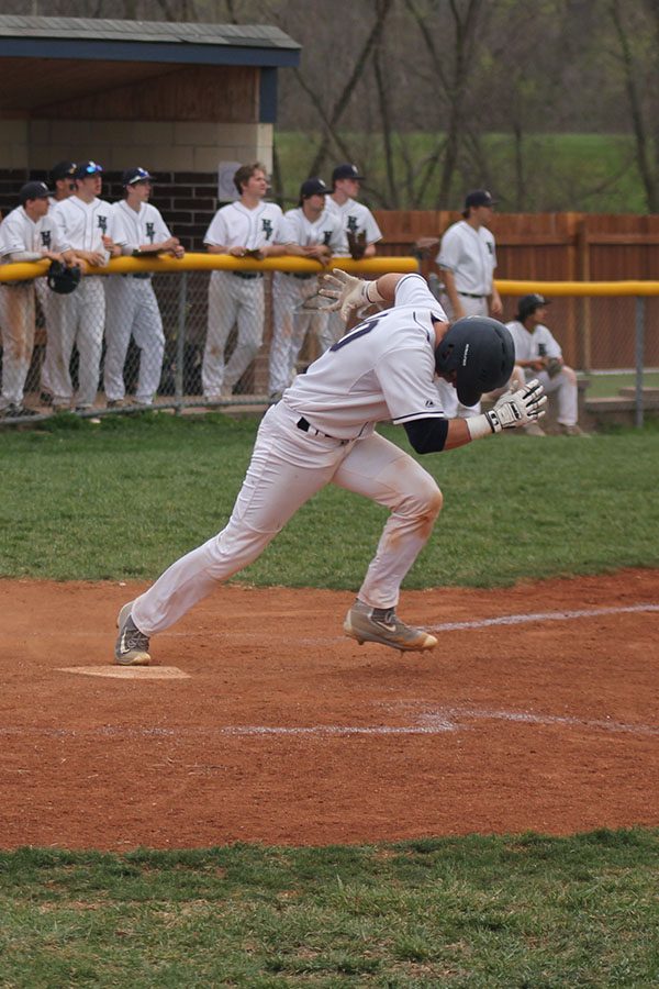 Putting his head down, senior Brayden Carr sprints for first base after successfully hitting the ball.