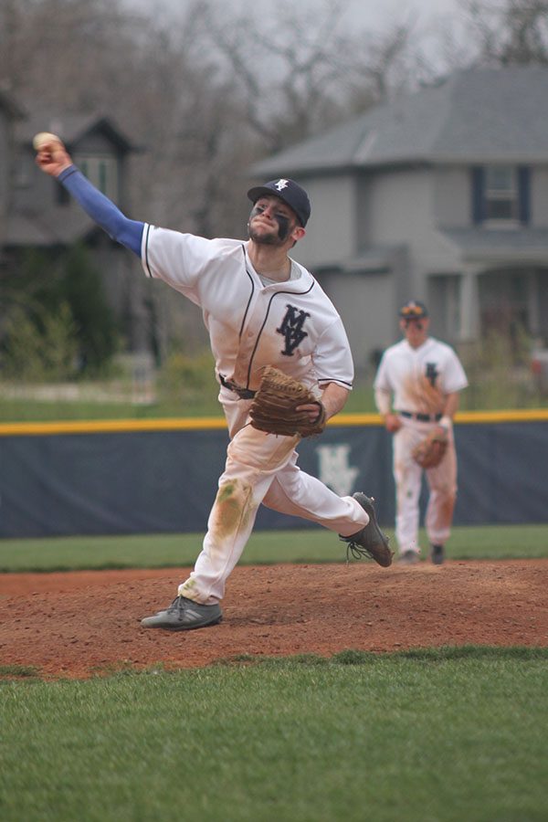 Extending his arm, junior Quinton Hall pitches the ball on Tuesday, April 24.