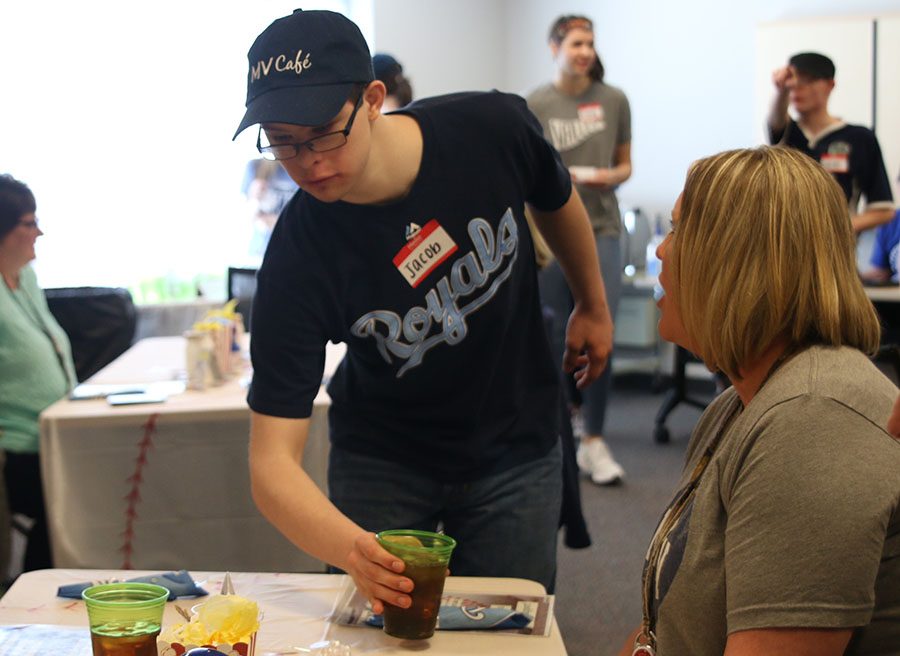 Wearing Royals gear for the Royals themed MV Cafe lunch, senior Jacob Tomandl refills a customers drink.