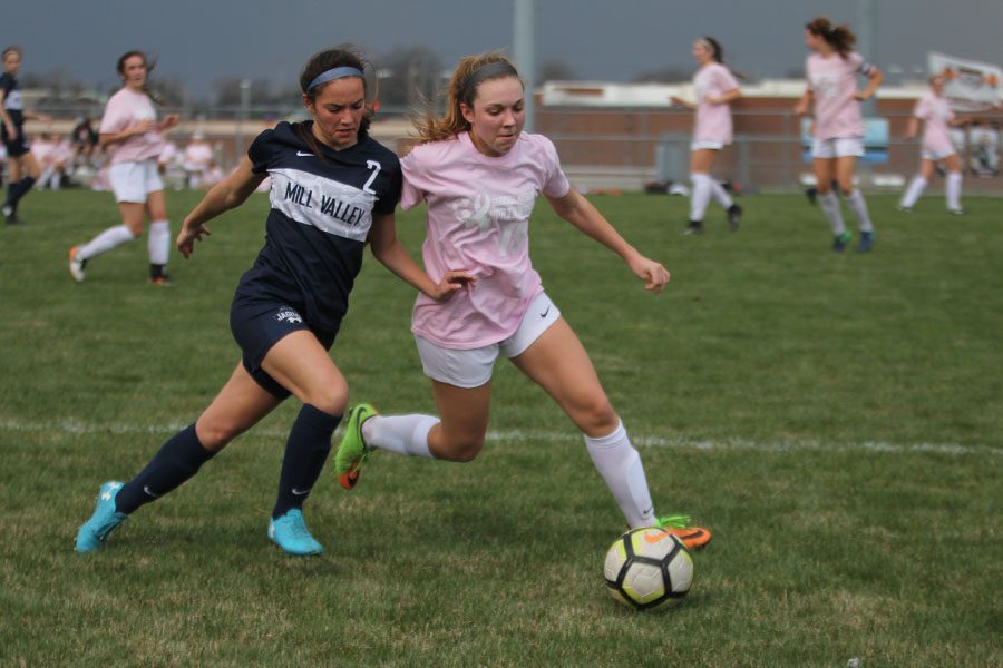Trying to reach the ball, freshman Peyton Wagoner outruns a SMNorthwest opponent on Friday, April 13. Despite a rain delay, the team won 2-1 against SMNorthwest.