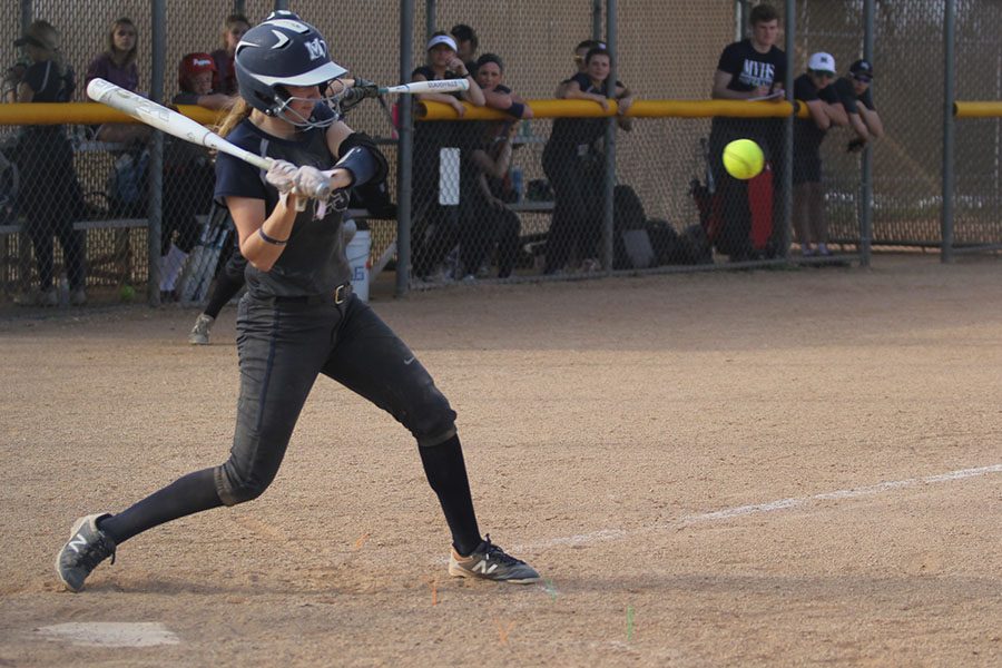 As the pitch comes in, junior Grace Lovett hits the ball.