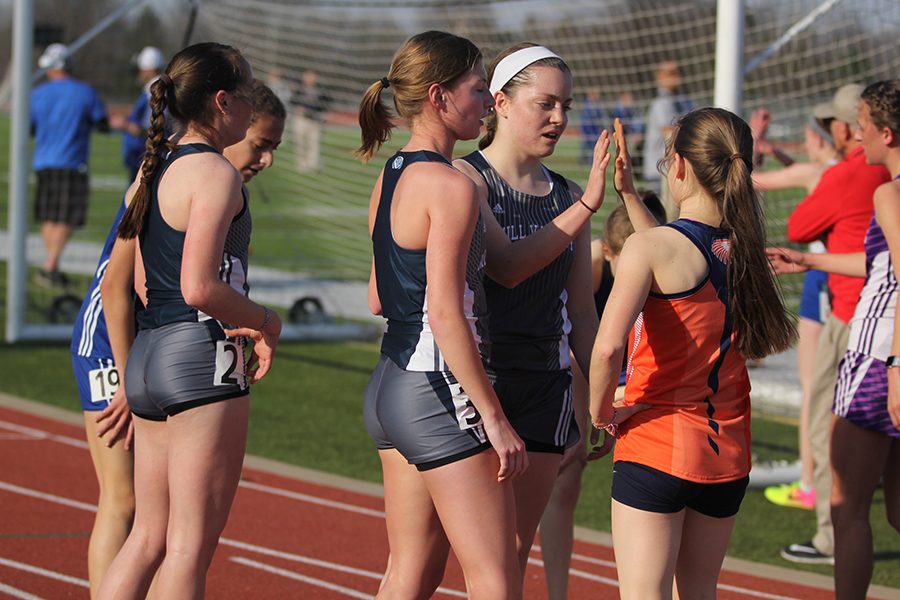 After all girls finished the 1600 meter, seniors Britton Nelson and Christine Lust high five an athlete from Olathe East. Junior Delaney Kemp placed second, Nelson placed third and Lust placed 13th.