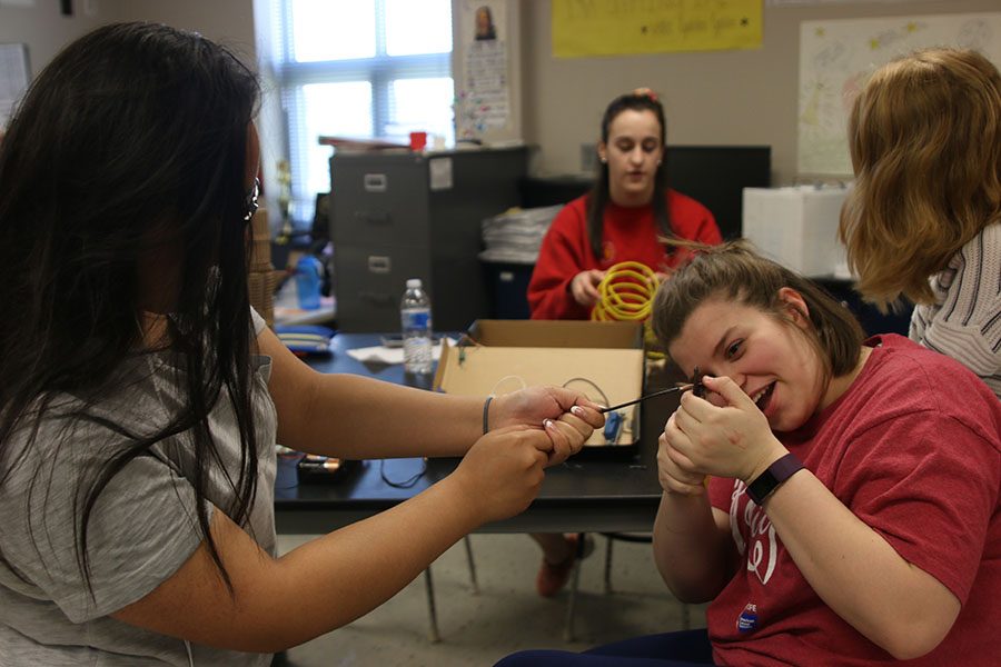 In efforts to expose the copper wire, juniors Crystal Sivilayvong and Lindsey Edwards pull at either ends of electrical wire on Tuesday, April 24.