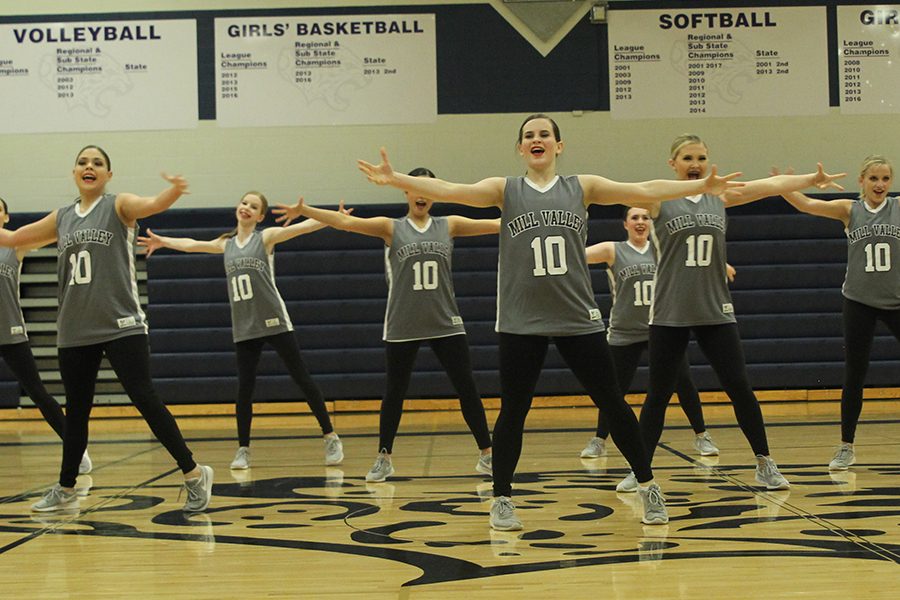 Arms stretched out, junior Olivia Augustine performs in the hip hop routine.