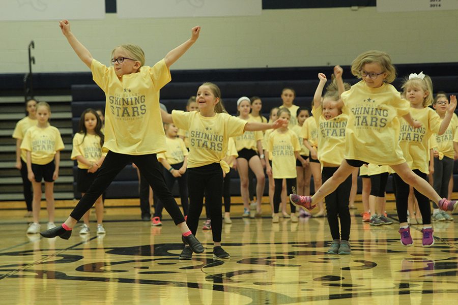 Jumping into the air, community members participate in the Shining Stars performance. 