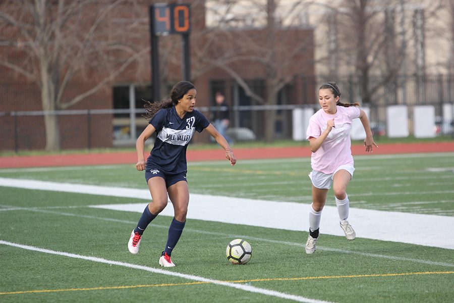 Facing pressure from a SMNorthwest player, freshman Madison Page tries to outrun her.