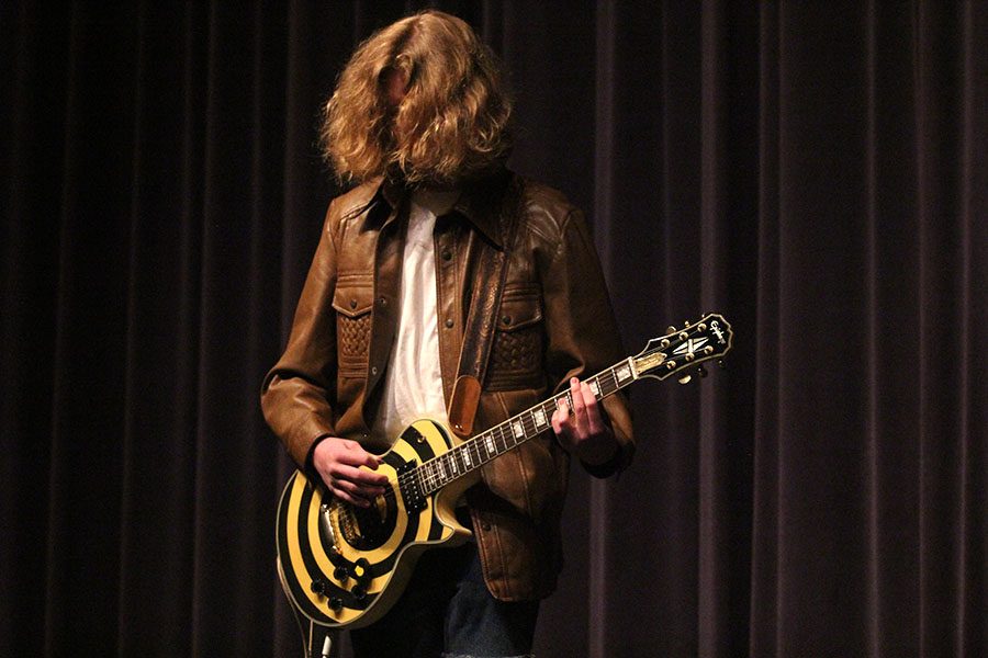 With his hair in his face, junior Killian O'Brien plays a guitar solo of "Sweet Child of Mine".