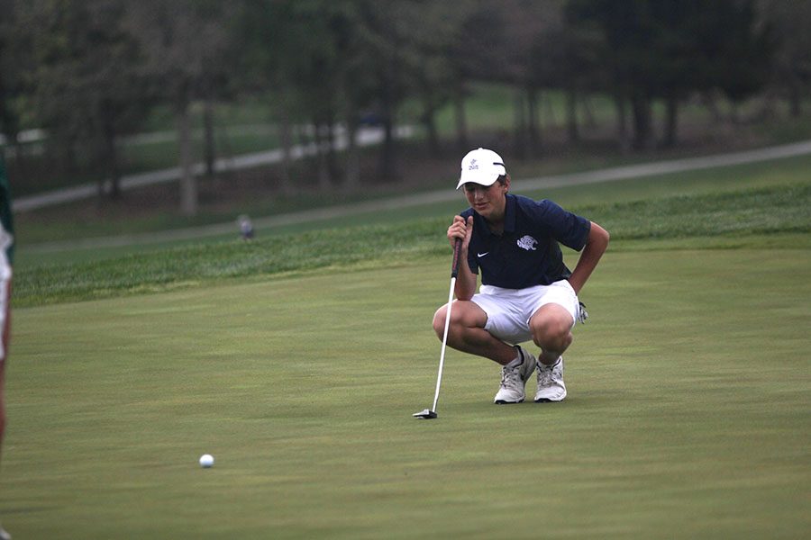 Squatting down, freshman Nicholas Mason gets a better look of his shot.