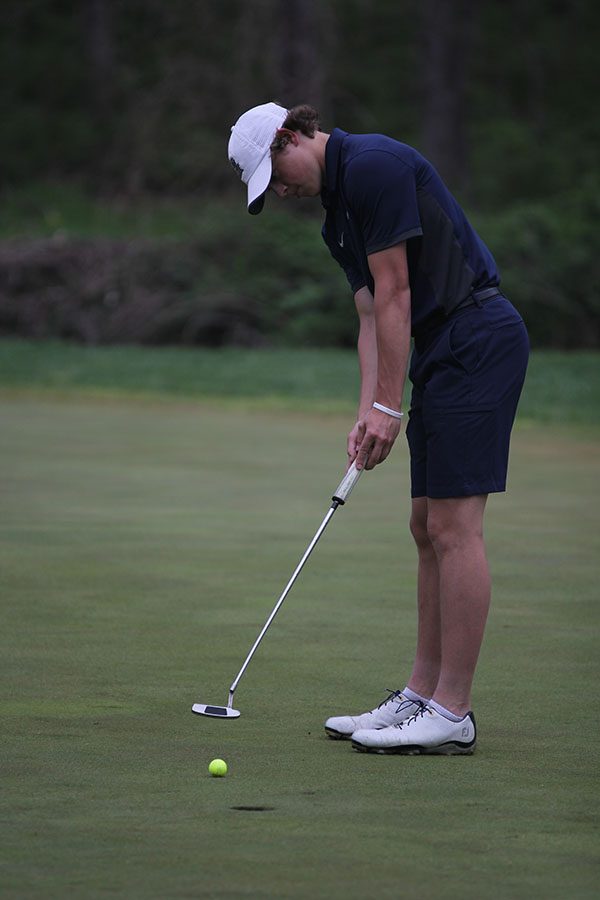 Putting the ball lightly, junior Tanner Moore finishes hole nine on Wednesday, May 2.