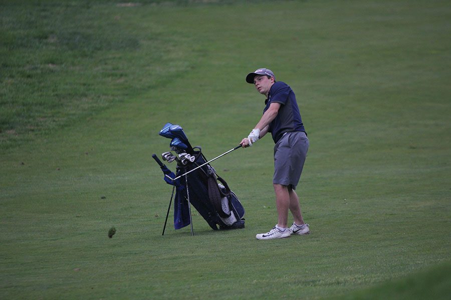 Following through on his swing, junior Jack Matchette lands the ball on the green of hole four.