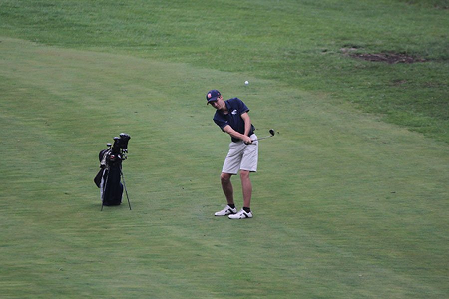 Standing on a hill across from the green, senior Kyle Bonnstetter drives his ball across the creek on hole nine.