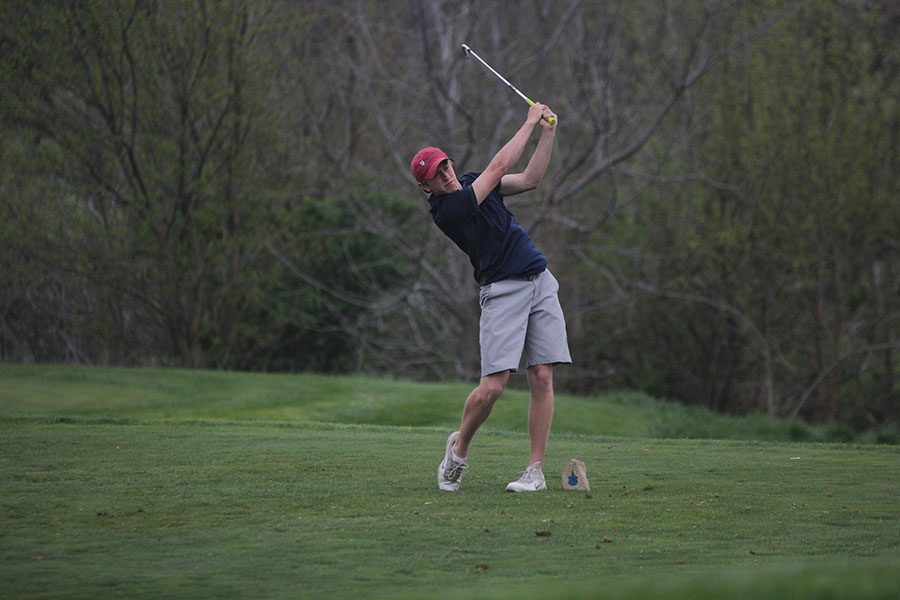 Teeing off, junior Nick Davie follows through on his swing on the last hole of the day.