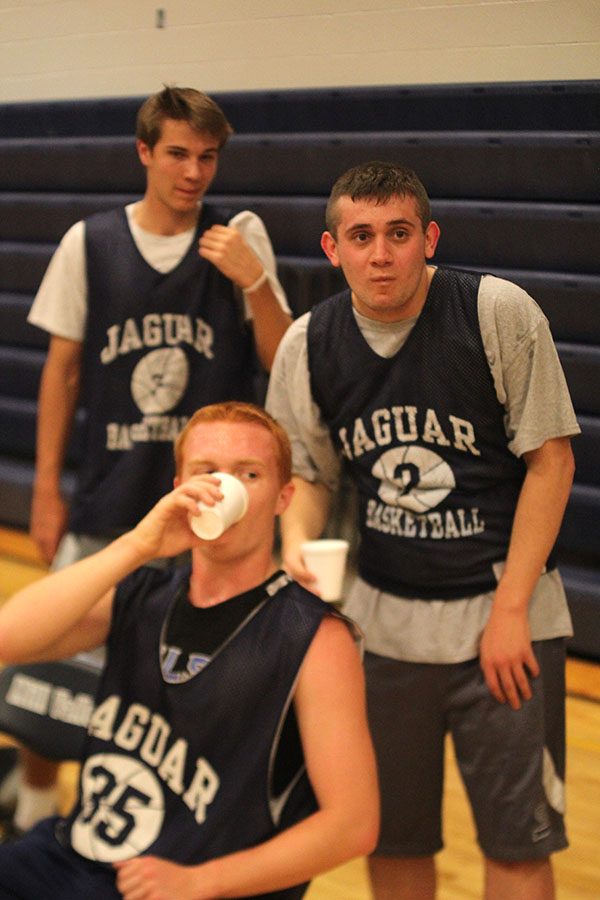 While resting during halftime, seniors Clark Harris and Mason Cole listen to teammates discuss strategy.