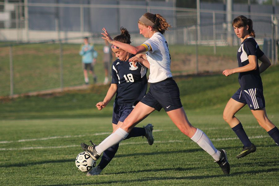 Leg extended, senior Cori Carver moves to block an opponents pass.