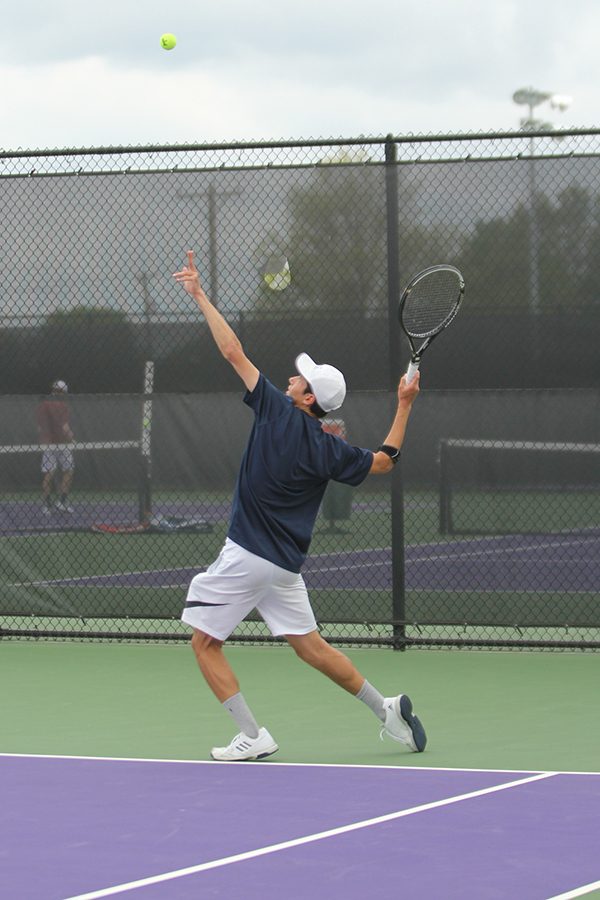After throwing the ball in the air, senior Drake Brizendine leans back in preparation to serve.