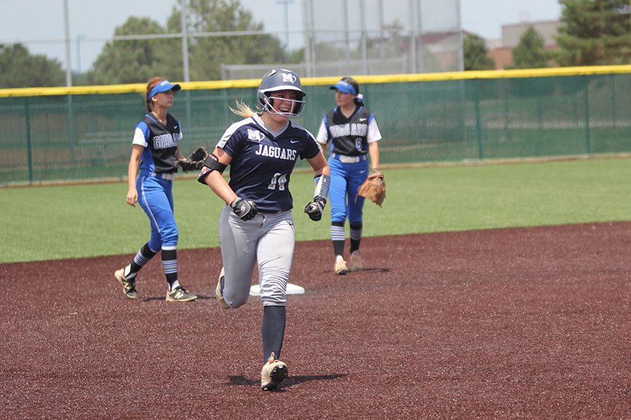 After hitting a home run, senior Peyton Moeder smiles as she makes her way to home plate. 
