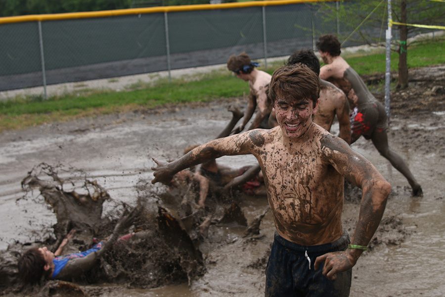 Running away, senior Max Whisler smiles as his friends fall in the mud.