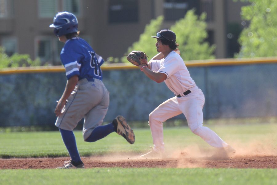 After grounding the ball, junior Johnathan Contreras throws the runner out at second base. 