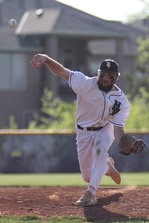 Taking a stride, junior Ethan Keopke pitches.