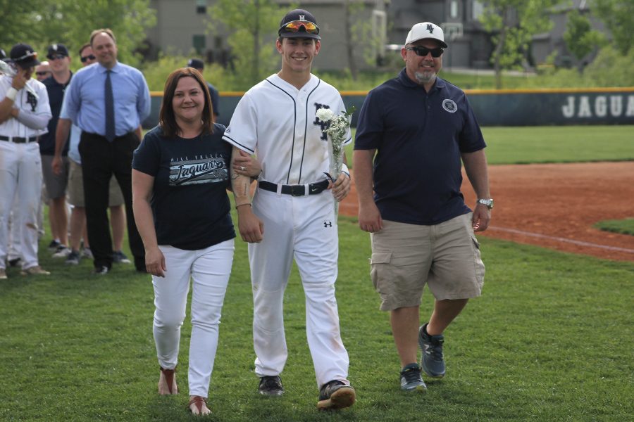 Accompanied by his parents, senior Brayden Carr is recognized on senior night.