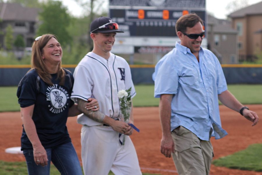 Walking out with his parents, senior Will Morris is recognized for senior night.