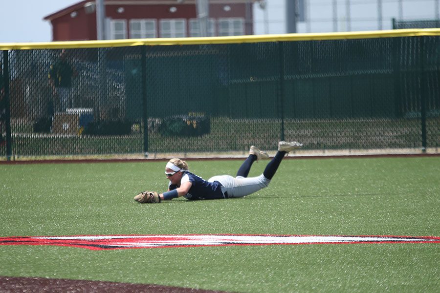 Catching a fly ball, senior Peyton Moeder slides on the field.