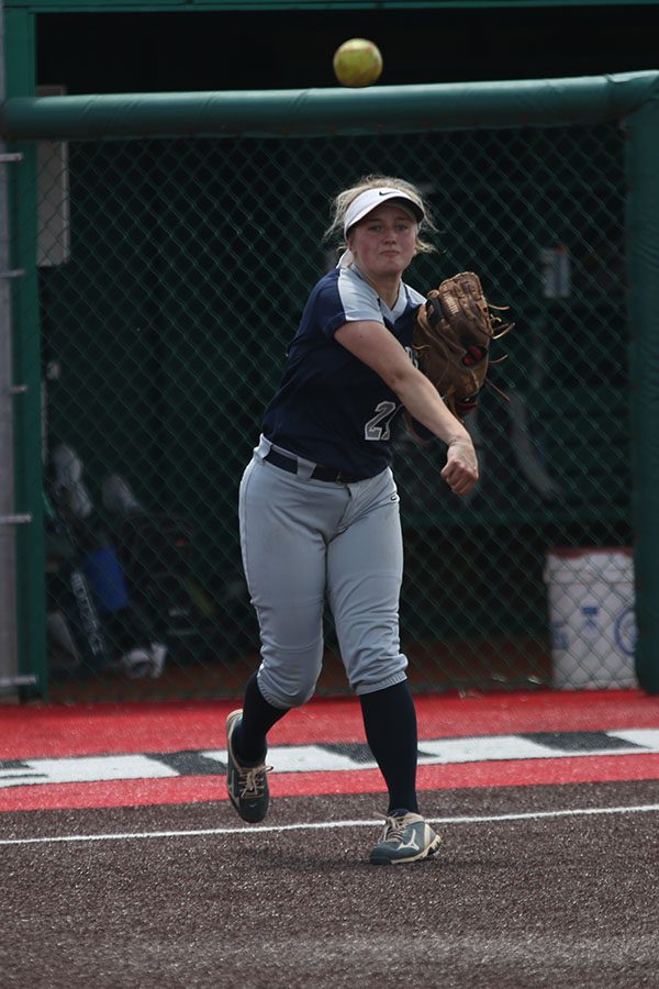 Sophomore Paige Oliver throws the ball to attempt to get a goddard player out.