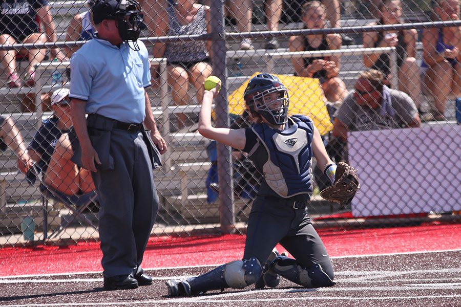 After catching a foul ball, junior Grace Lovett throws the ball back to the pitcher.