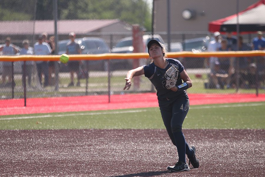 Freshman Ava Bredwell throws ball the ball back to the pitcher.