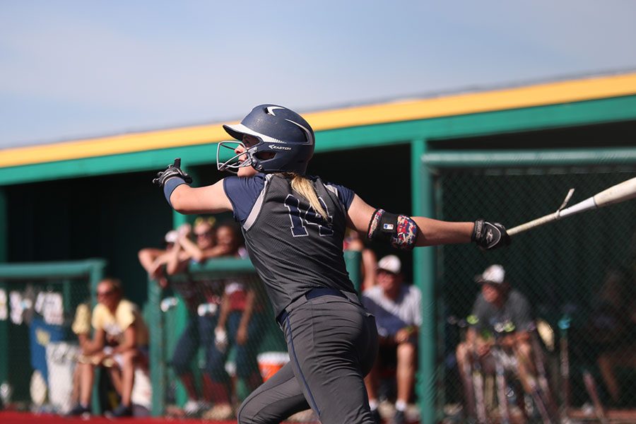 After hitting the ball, senior Peyton Moeder looks to see where the ball went before running to first base.