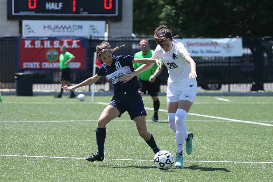 As she sticks her arm out, senior Payge Bush attempts to get possession of the ball.