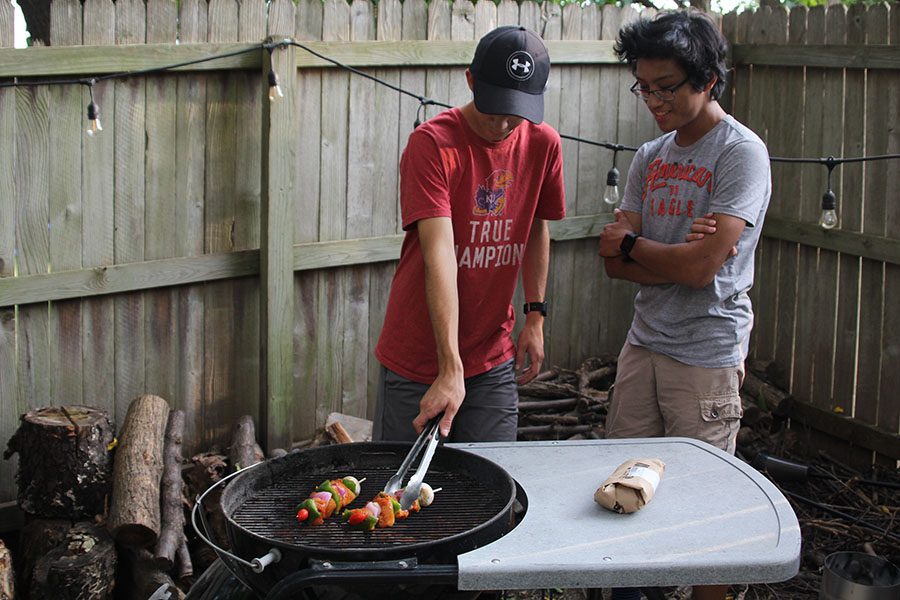Grilling their chicken kabobs on Sunday, Aug. 5, juniors Logan Arnold and Nico Gatapia like spending time over the summer grilling and cooking together. “I enjoy cooking because it is a way for me to learn a new skill for later in life,” Gatapia said.// Andrew Tow

