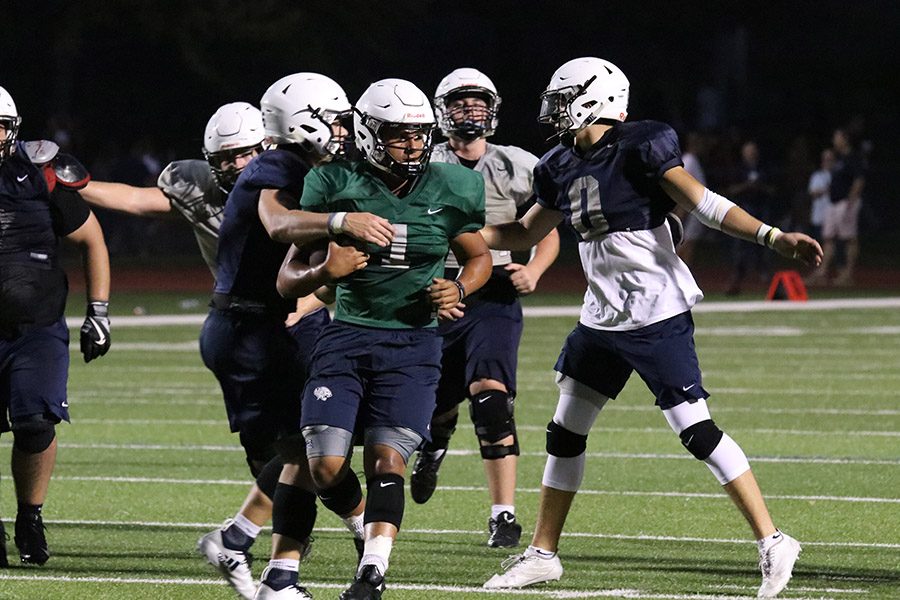 After running down field on Friday, Aug. 24, senior Jordan Preston gets tapped down at Friday Night Lights.   