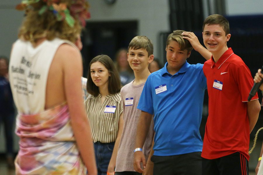 Playing a coin flip game, freshman Cadynce Marlow places his hand on his head. 