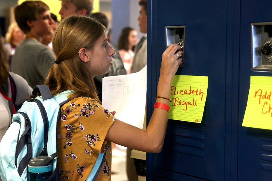 Holding up her schedule, freshman Elizabeth Basgall opens her locker. 