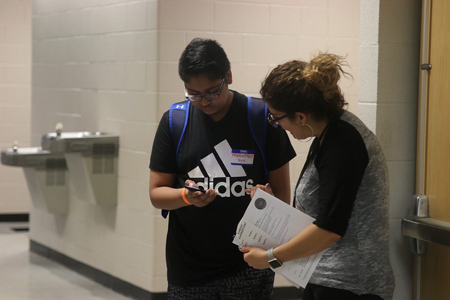 Looking at his schedule, English teacher Coral Brignoni helps freshman Prabhpreet Virk find his next class. 