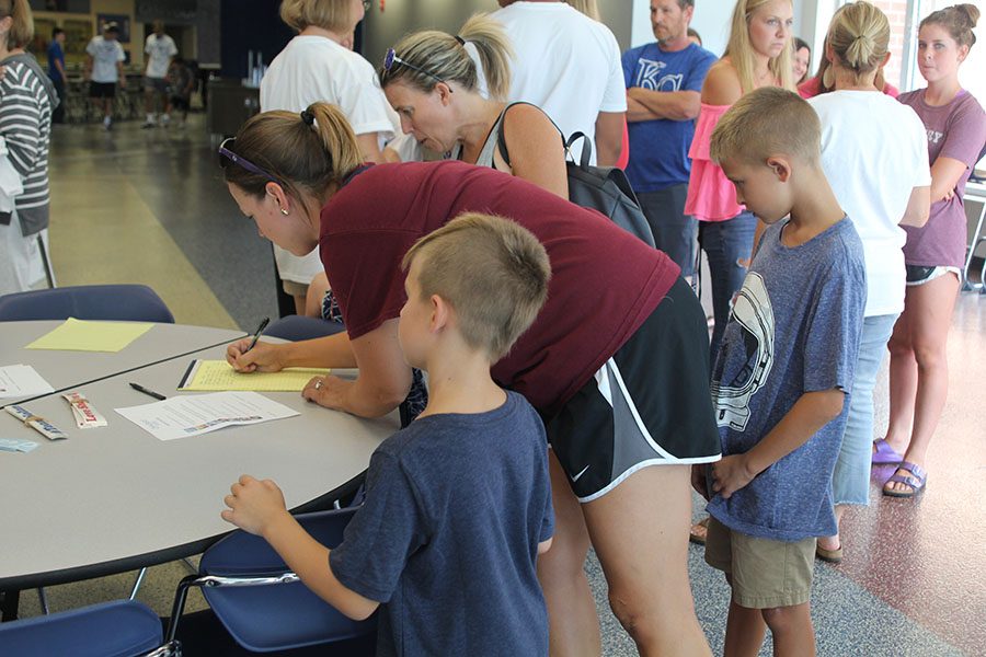 With her two kids, English teacher Ashley Agre orders a Team Nolan shirt on Wednesday, Aug. 15.