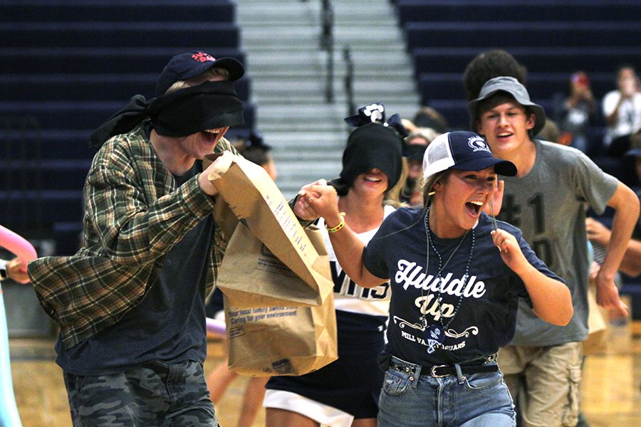 Participating in the homecoming candidate obstacle course during the pep assembly on Friday, Sept. 7, senior Lilli Milberger leads blindfolded senior Jack Mahoney through the obstacles. 