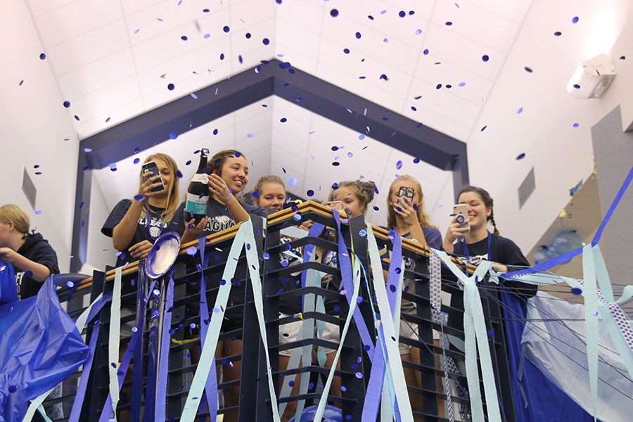 Standing at the balcony, senior Nicole Wieschhaus pops a confetti cannon.