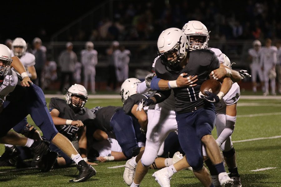 Fighting against BVN defense, senior Cameron Young runs with the ball to gain a few yards. Despite a hard fought game, the team lost to BVN 41-16 on Friday, Sept. 28. “[Coming back from an injury] I just had to slowly work up over the weeks and get my leg stronger,” Young said.