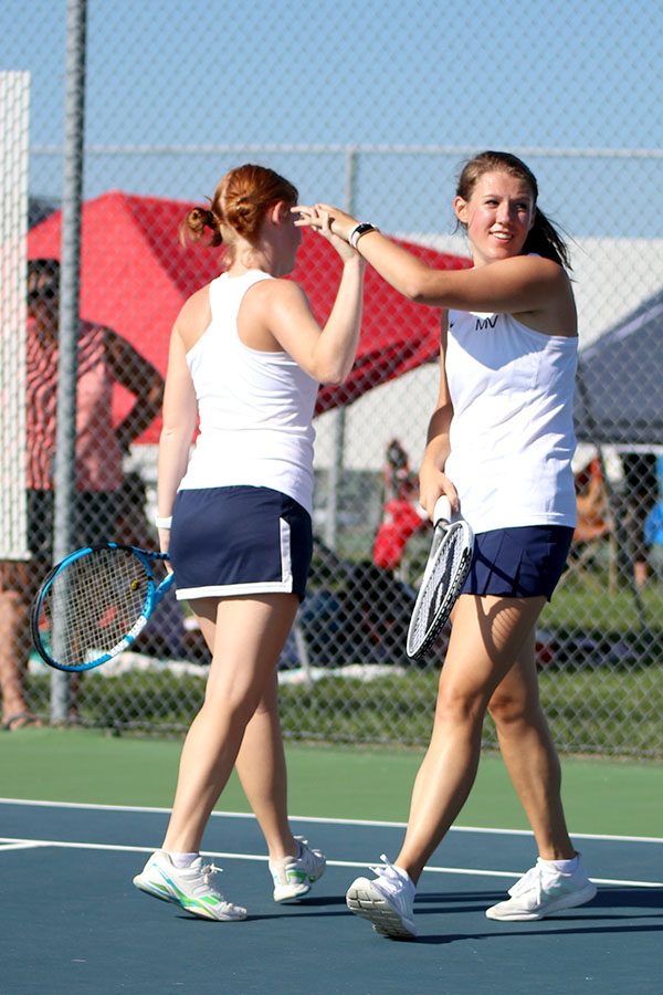 Josie Carey and Anika Roy high-five after scoring a point. The doubles duo placed 3rd in their respective bracket during the nine team tournament on Saturday Sept. 15.